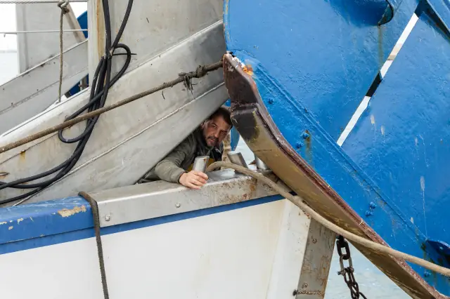 Détail de la coque bleue et blanche d’un bateau de pêche