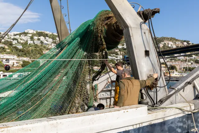 Pêcheurs manipulant les filets à bord