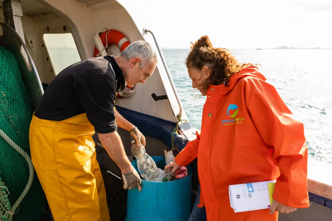 Pescadors descarregant caixes blaves al moll de Roses